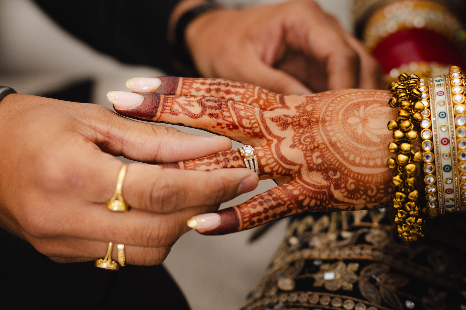 Bride's henna-adorned hand with engagement ring